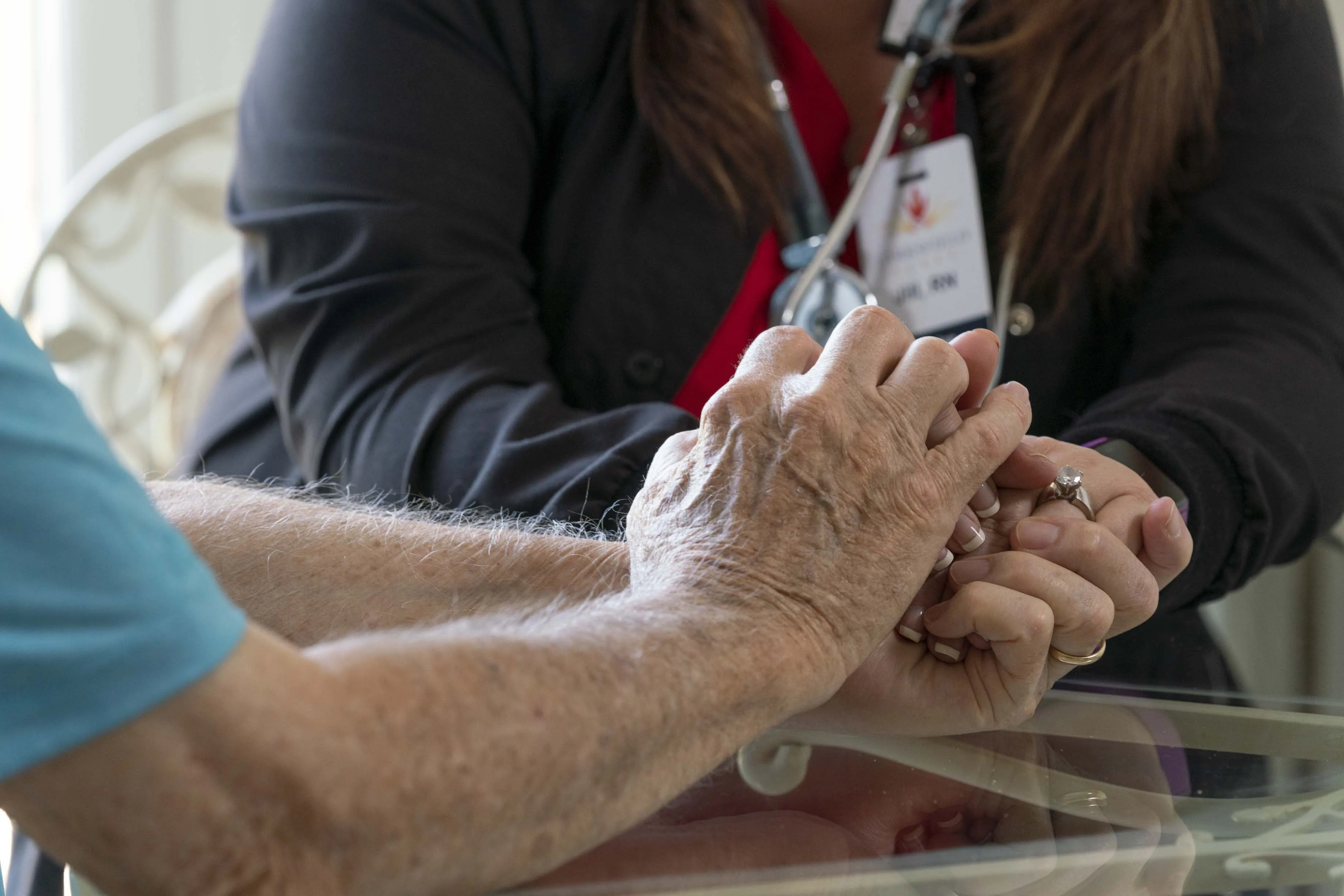 A nurse holding a residents hand