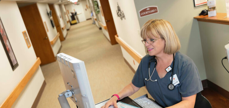 RN Typing On Computer In Health Center