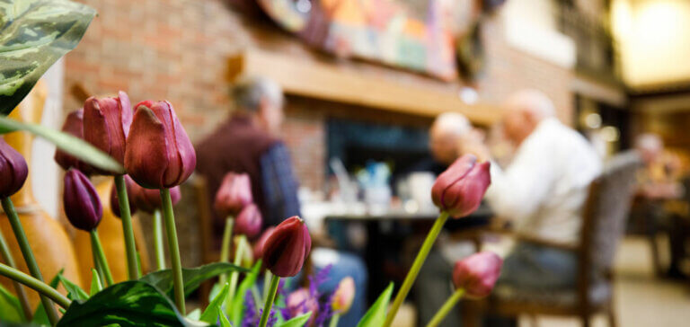 Seniors Dining At Restaurants Behind Flower Decorations