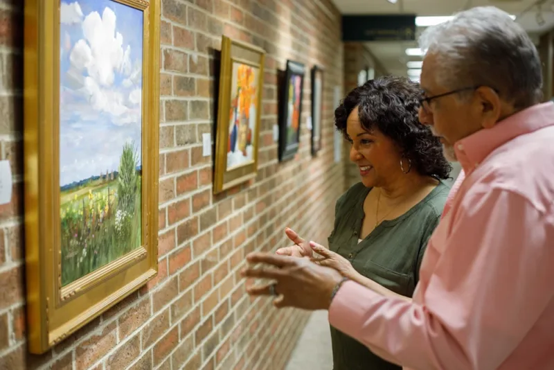 Man and woman talking about resident artwork