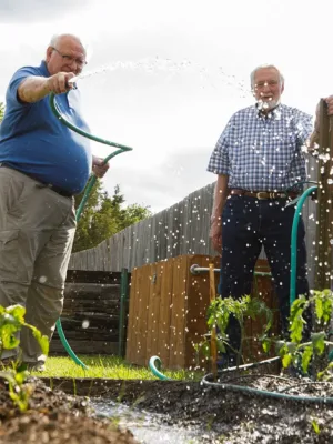 Two men watering the garden