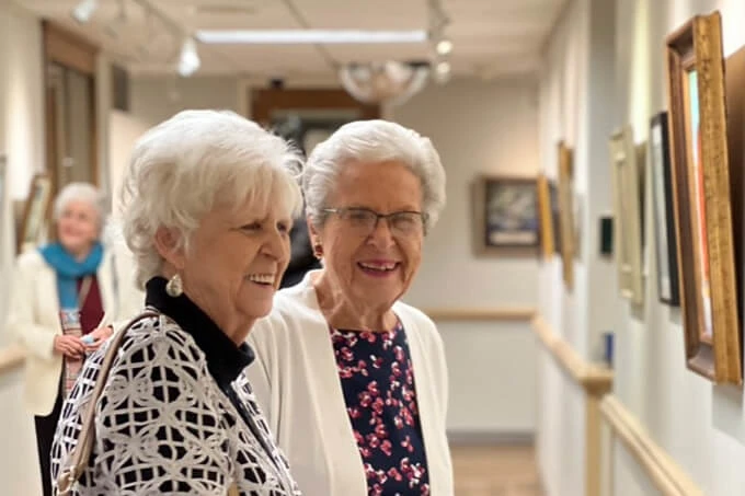 Two women looking at paintings